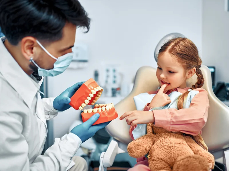 Bambina da la mano al dentista
